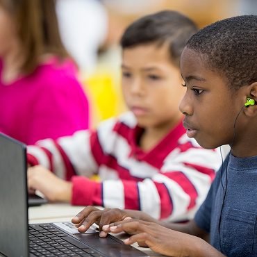 Children typing on laptops